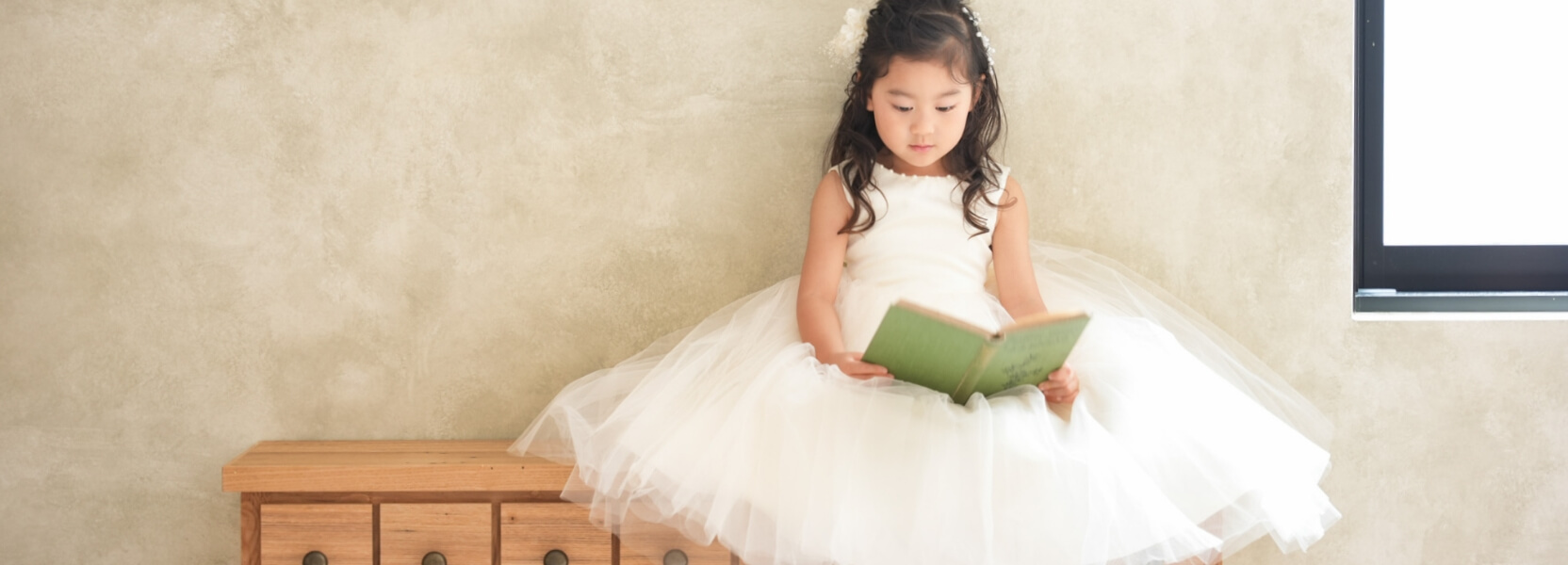 ドレスを着た女の子が本を読む